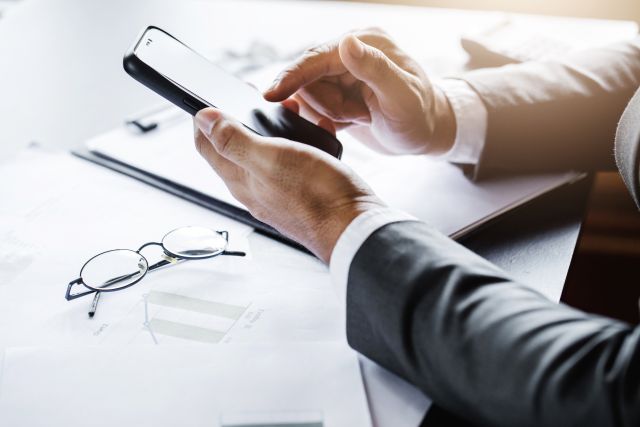 Photographie dite close-up qui fait un focus sur des mains tenant une paire de lunettes, évoquant pour l'occasion une attitude de réflexion introspective